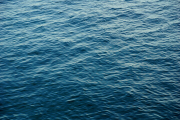 Fototapeta premium Shiny gradient blue sea surface with small waves and light reflection on the top of the water
