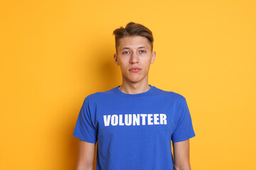 Portrait of young volunteer on orange background