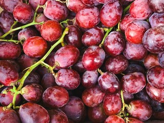Fresh red grapes piled together in a close up view
