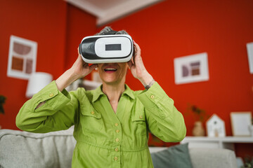 mature woman enjoy while use VR virtual reality goggles at home