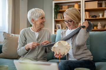 Obraz premium Senior women knitting and sewing together at home
