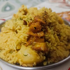 A plate of flavorful spiced rice mixed with potatoes and topped with tangy pickle. A simple yet satisfying homemade dish loved across South Asia.