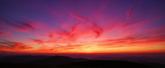 Vibrant glowing sky over mountains at twilight, magical landscape