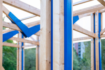 Structural wooden beams forming frame commercial building under construction in natural light, structural elements, raw materials