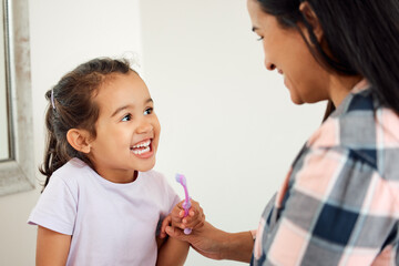 Fototapeta premium Brushing teeth, dental and smile of mother and daughter in bathroom of home for hygiene together. Cleaning, love or teeth with single parent woman and girl child in apartment for morning routine