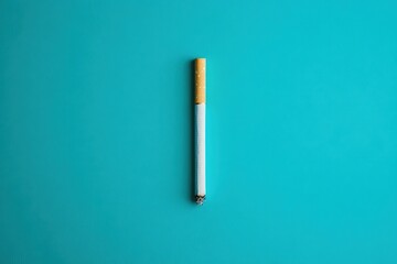 A single burning cigarette against a bright blue background