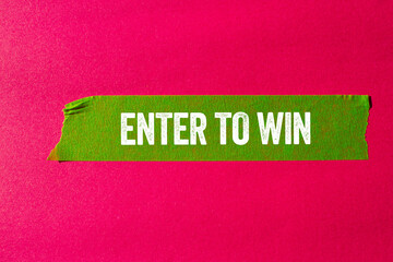 Enter to win message written on ripped torn green paper tape on pink background. Conceptual enter...