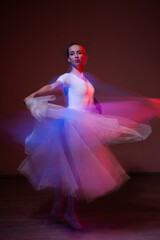 Fototapeta premium Caucasian woman dancing classical dance in tutu . Long exposure photo. 