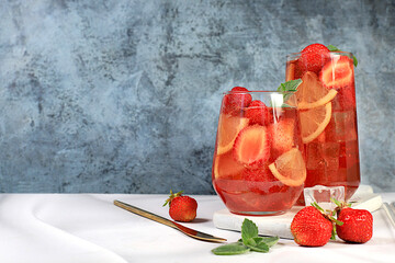 Strawberry iced tea or mint lemon cocktail, refreshing summer drink recipe. Glasses with berry...