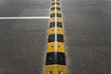 Progi zwalniające z wyraźnym oznakowaniem pasów. Detal miejskiej infrastruktury drogowej