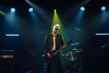 Guitarist performing on stage with dramatic lighting
