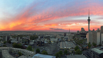 City view of a deep red reflected Sun in the clouds of Auckland one evening