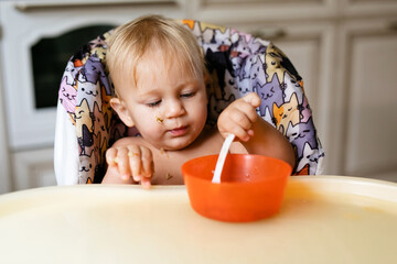 Baby sitting in highchair eating food