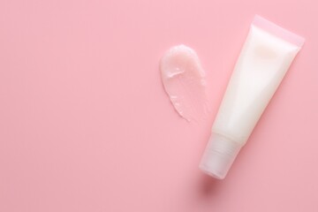 Tube with moisturizing lip balm on pink background, top view. Space for text