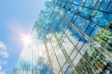 Modern skyscraper and lush trees against blue sky, double exposure. Low angle view