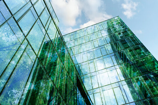 Modern building and lush trees against blue sky, double exposure. Low angle view - Powered by Adobe