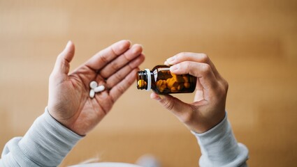 Fototapeta premium Sick ill asian young woman, girl hold tablet pill on hand pour capsule from medication bottle, painkiller medicine from stomach pain, head ache, pain for treatment, take drug or vitamin, health care.