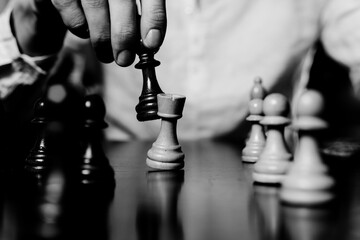 Close-up of male hand moving chess piece on board. Strategic decision making during intense game....