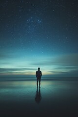Fototapeta premium A solitary person standing on a beach beneath a starry sky