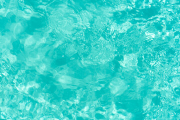 Fototapeta premium Blue water with ripples on the surface. Defocus blurred transparent blue colored clear calm water surface texture with splashes and bubbles. Water waves with shining pattern texture background.