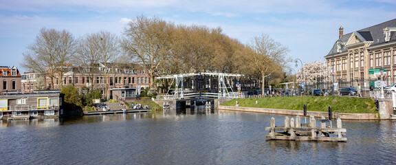 Picturesque panorama of Muntgebouw and high rise office buildings behind long white canal bridge