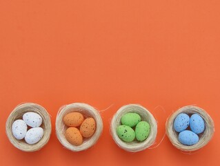 Straw nests with decorated Easter egss on orange background. Easter background.