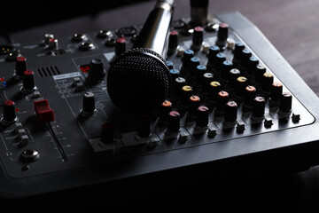 Professional mixing console with microphone on table, closeup