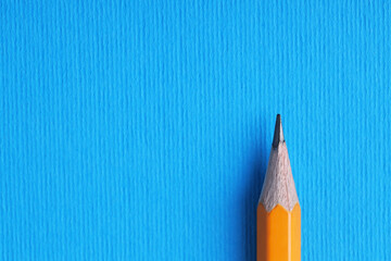 One pencil on light blue background, top view. Space for text