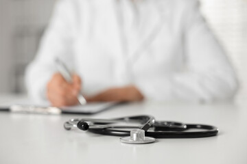 Fototapeta premium Doctor working and stethoscope on table in hospital, selective focus