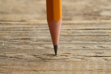 One sharp graphite pencil on wooden table, closeup