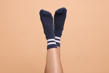Woman in stylish socks on beige background, closeup