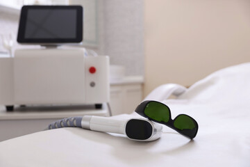 Laser hair removal device and protective glasses on medical couch in beauty salon