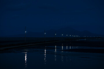 干潮の海に伸びる長部田海床路の灯り