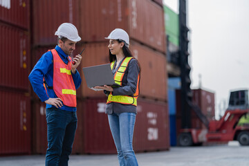 Two logistics workers man and woman discuss operations at a busy shipping container yard. successful coordination in freight, transportation, and supply chain operations