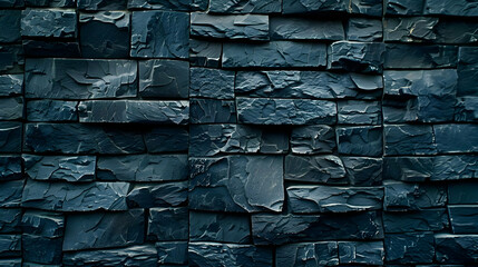 A textured wall made of dark slate stones, showcasing a modern architectural design.