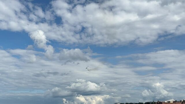A jet is flying in the sky above a blue sky with clouds. The sky is clear and the clouds are scattered
