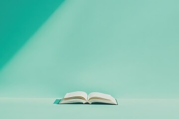 An open book rests on a pastel green surface of sorts