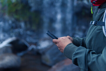 Hiker using smartphone near apatlaco waterfalls in mexico