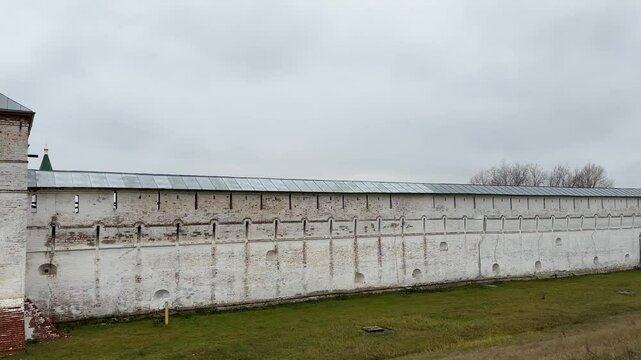 Large white building with a red roof and a tower. The building is surrounded by a grassy area