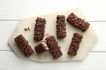 Delicious chocolate puffed rice bars on white wooden table, top view