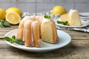 Delicious lemon cake with glaze and mint on wooden table, closeup