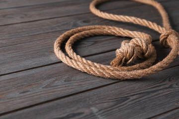 Lasso made of cotton rope on wooden background, closeup