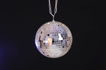 One shiny disco ball on dark background