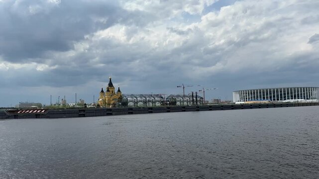 In the background is the Alexander Nevsky Cathedral. Nizhniy Novgorod. View from the Volga River. The sky is overcast and the water is calm