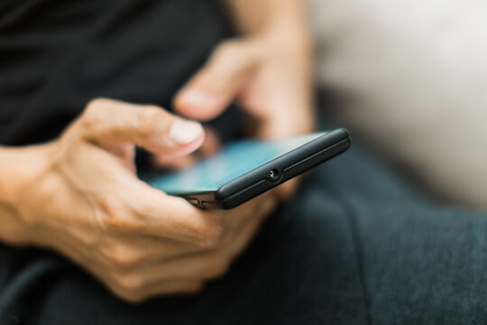closeup of a man texting on a cell phone device