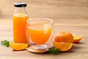 Orange juice in glass and bottle with fresh orange fruit on wooden background, Healthy drink