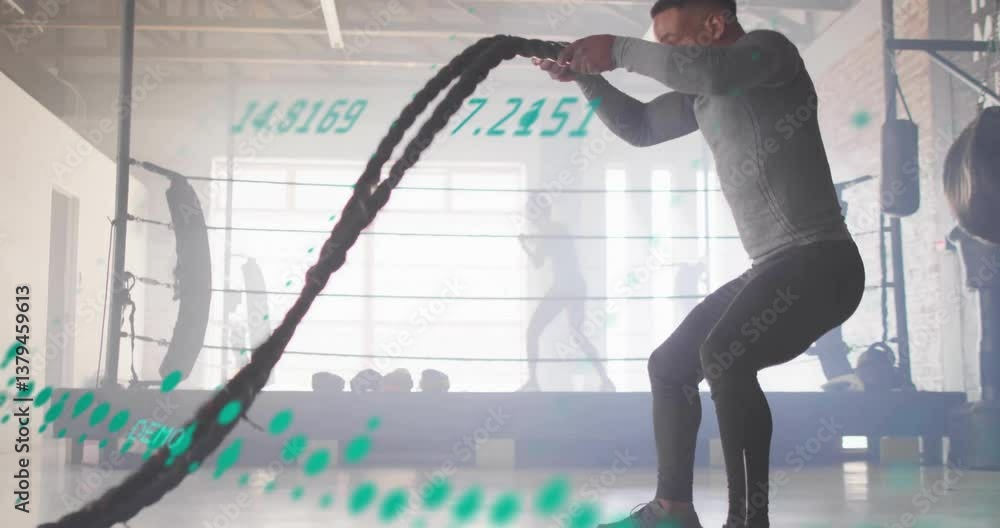 Poster man exercising with battle ropes, digital data animation overlaying gym scene