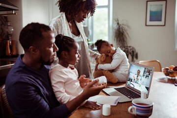 Young family talking to their family pediatrician over a video call on their laptop