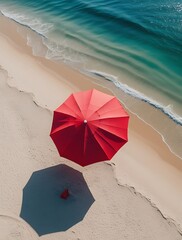 Naklejka premium Aerial view of a vibrant red beach umbrella casting a shadow on soft golden sand near the turquoise sea, evoking relaxation, summer vacations, tropical destinations, and coastal serenity.