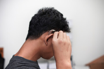 Asian boy with hearing aid device